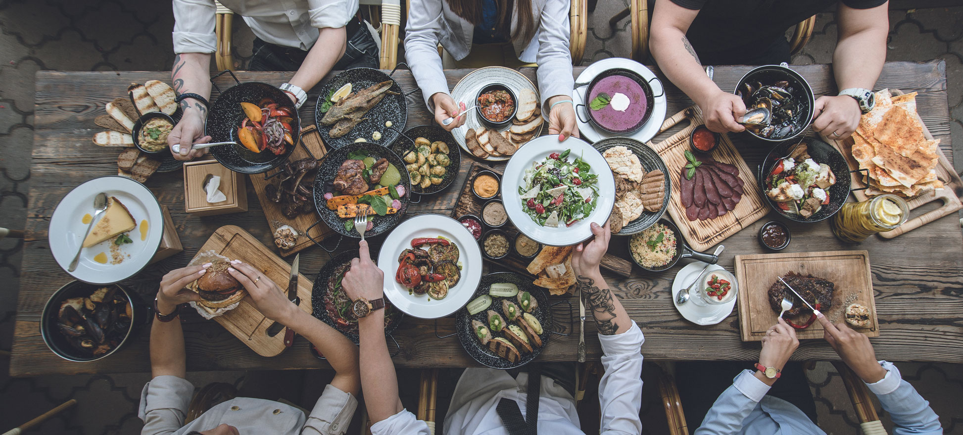 High angle shot of a holiday spread/holiday table full of food and people filling their plates.