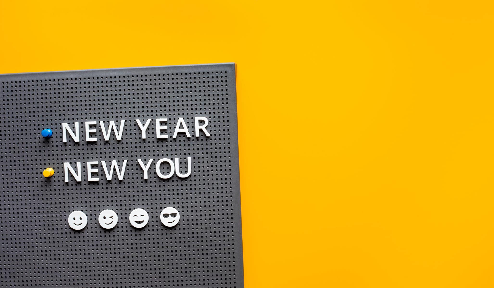 Words "new year new you" on a board in a yellow backgound.