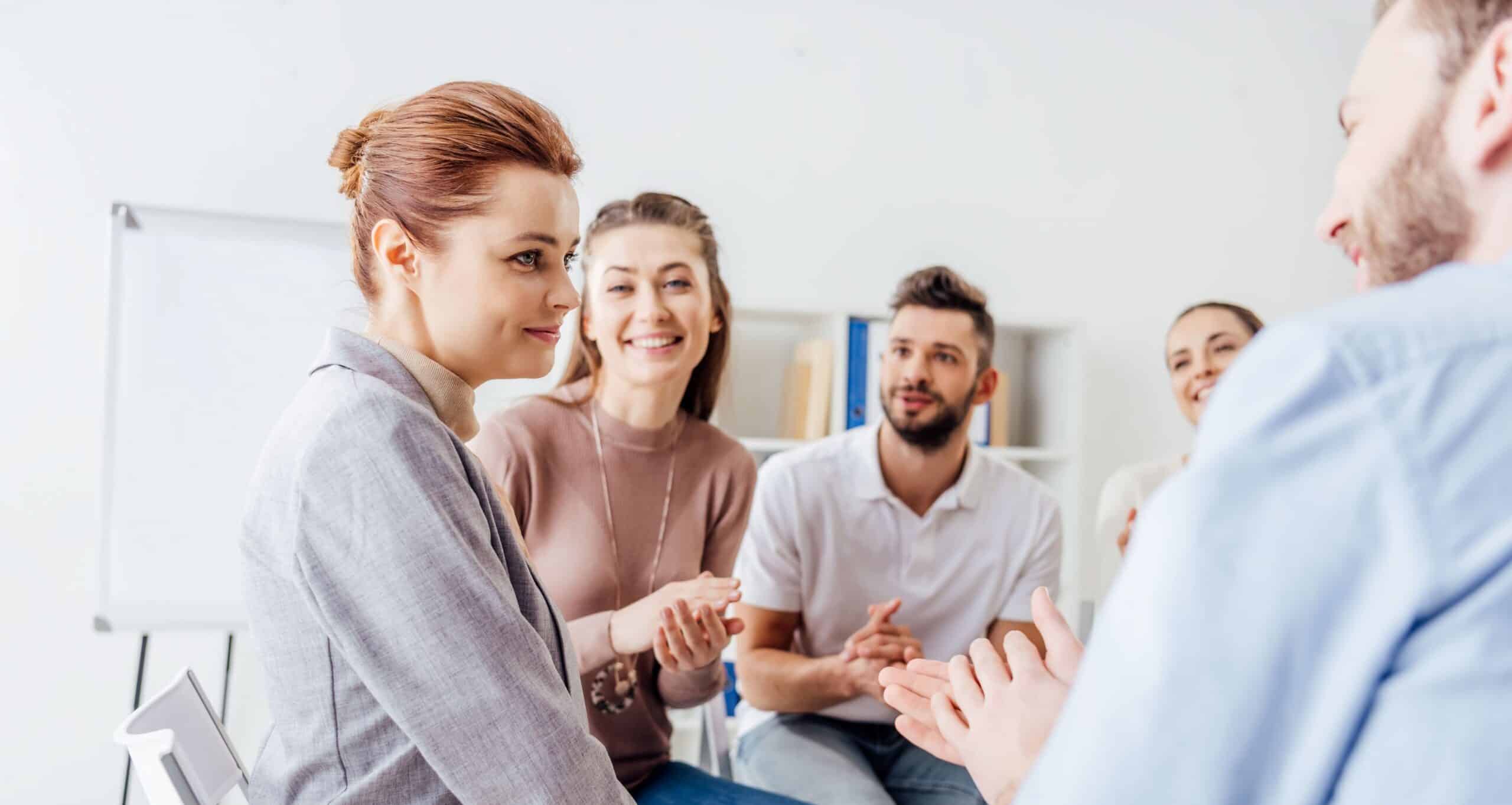 Woman looking relieved surrounded by a group of supportive people.