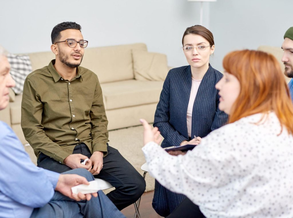 An LMFT, which stands for licensed Marriage and Family Therapist, conducting a psychotherapy session with a group of people | Why do therapists have so many different credentials? by Soultenders