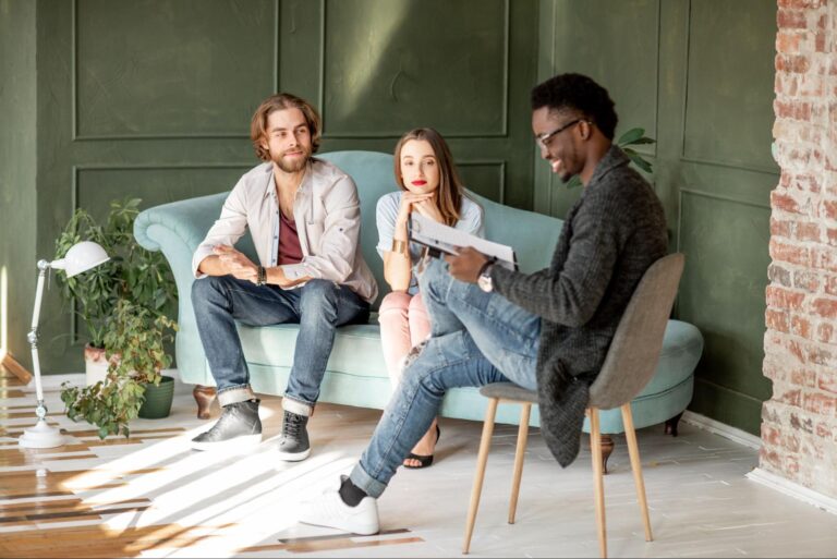 An LMFT, which stands for licensed Marriage and Family Therapist, conducting a therapy session with a young couple | Why do therapists have so many different credentials? by Soultenders